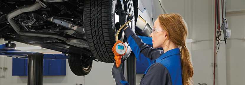A Subaru technician checking tire pressure. | Cook Subaru in Steamboat Springs CO